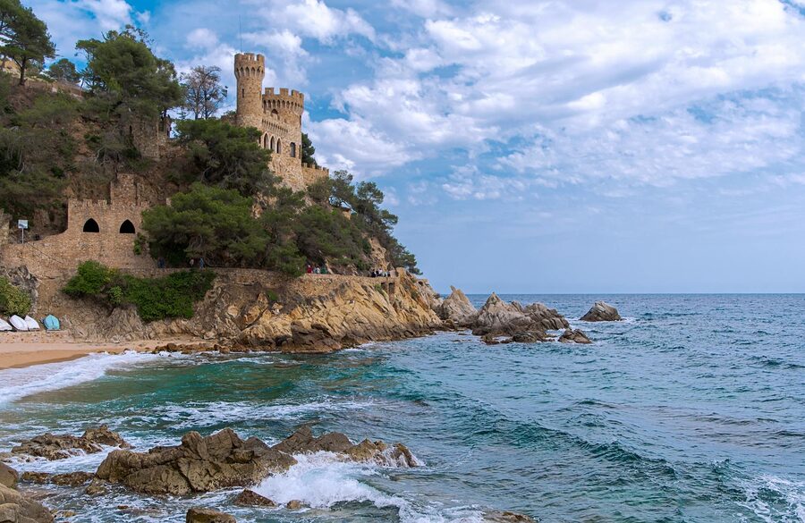 Castle perched on a cliff above the sandy beach at Lloret de Mar