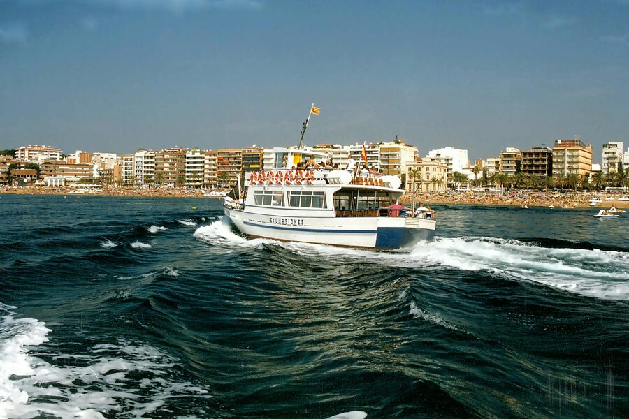 Passenger ship cruising near the coastal skyline of Lloret de Mar