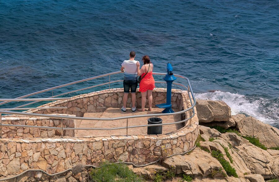 Couple standing on a lookout platform enjoying the sea view at Lloret de Mar