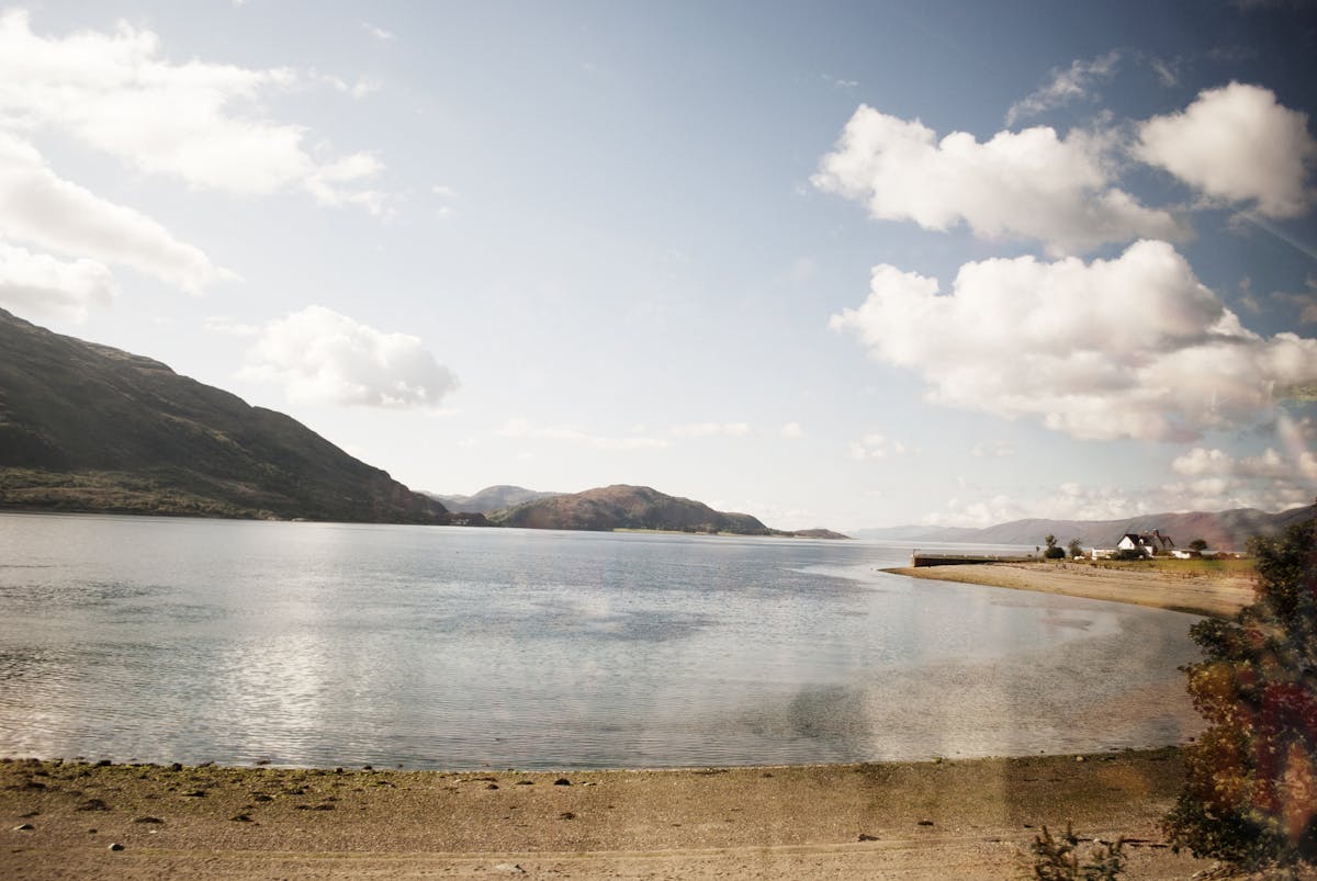 Tranquil lakeside landscape in the Scottish Highlands with mountains and clouds