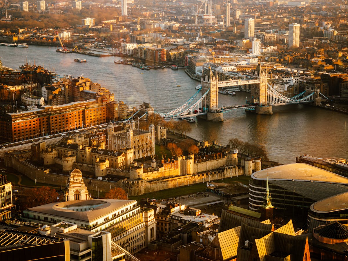 Aerial view of London at sunset showing Tower Bridge and the Thames winding through the city