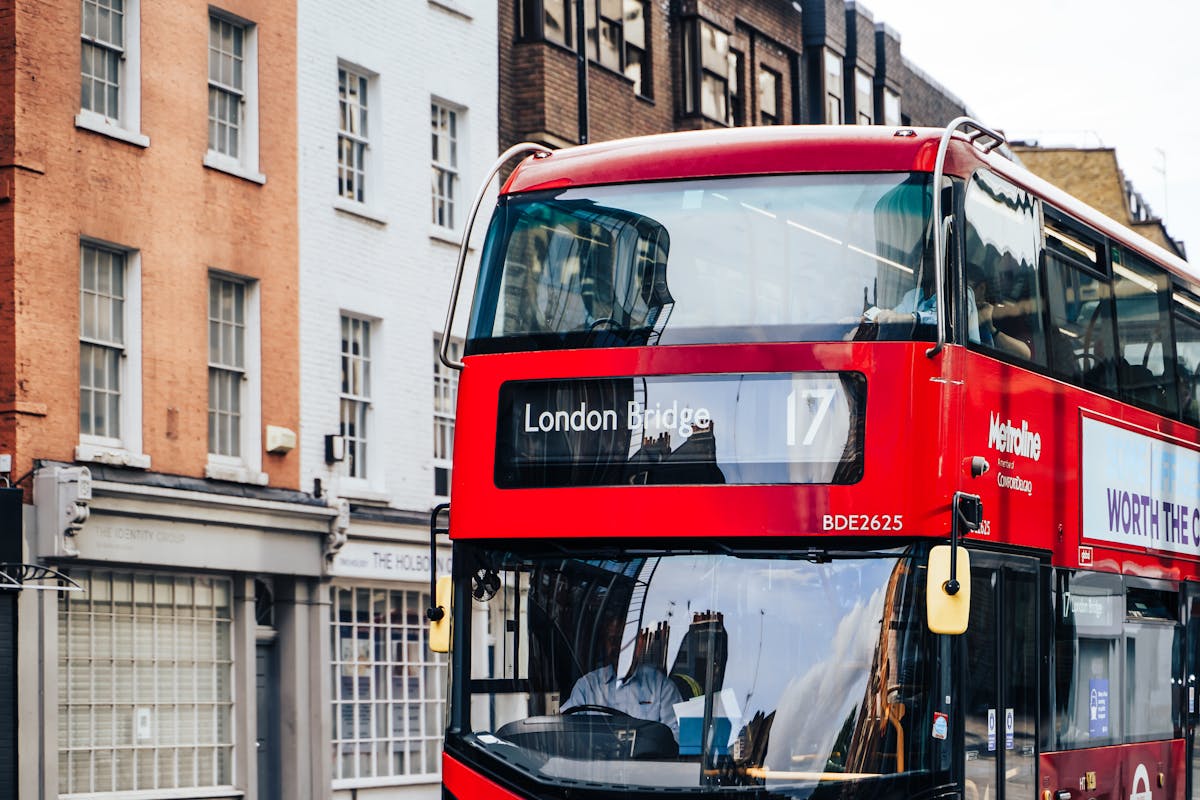 A classic red double-decker bus driving through central London