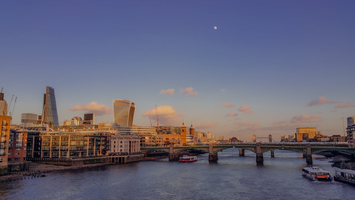 The Thames winding through London with modern skyscrapers catching the last twilight