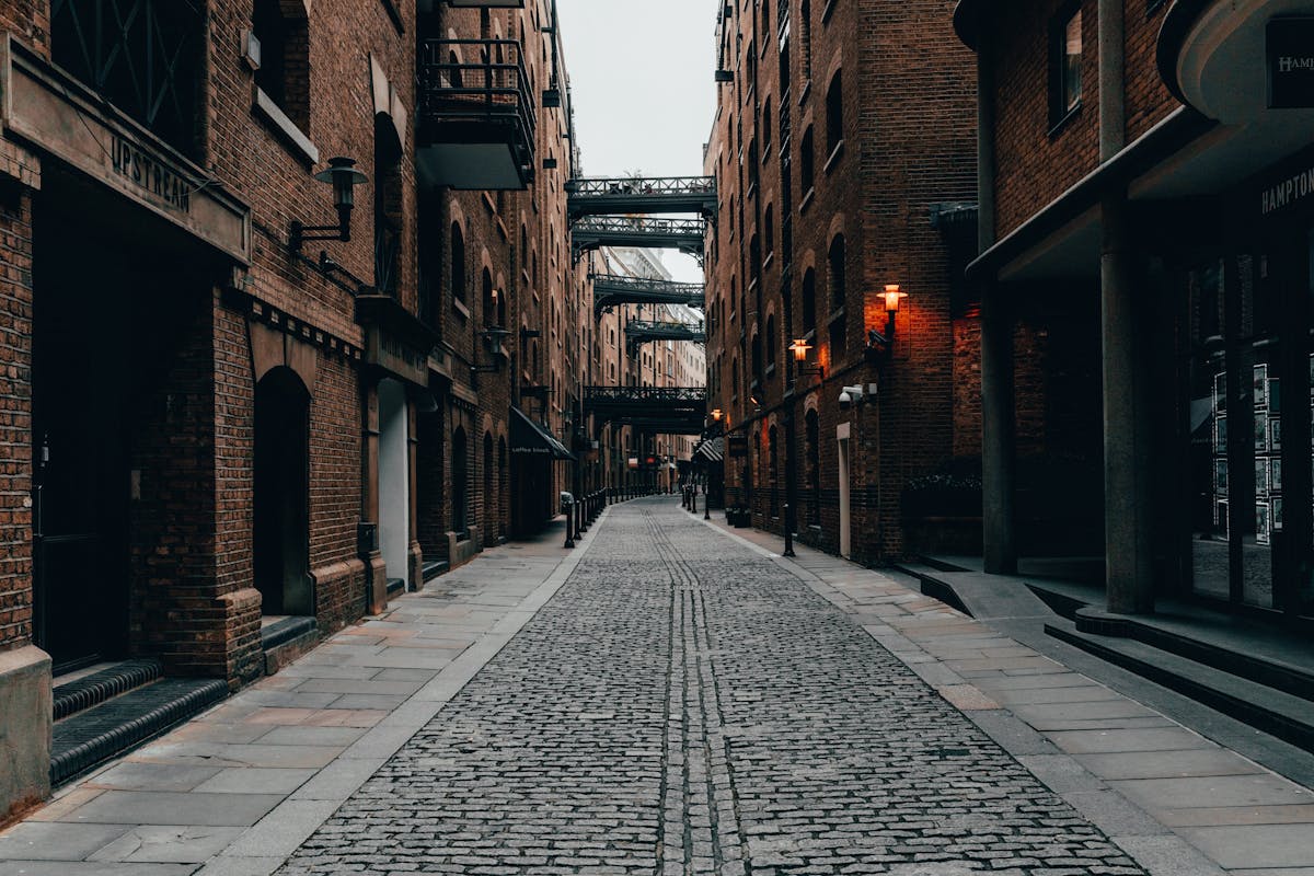 Narrow cobblestone alleyway between brick buildings in London