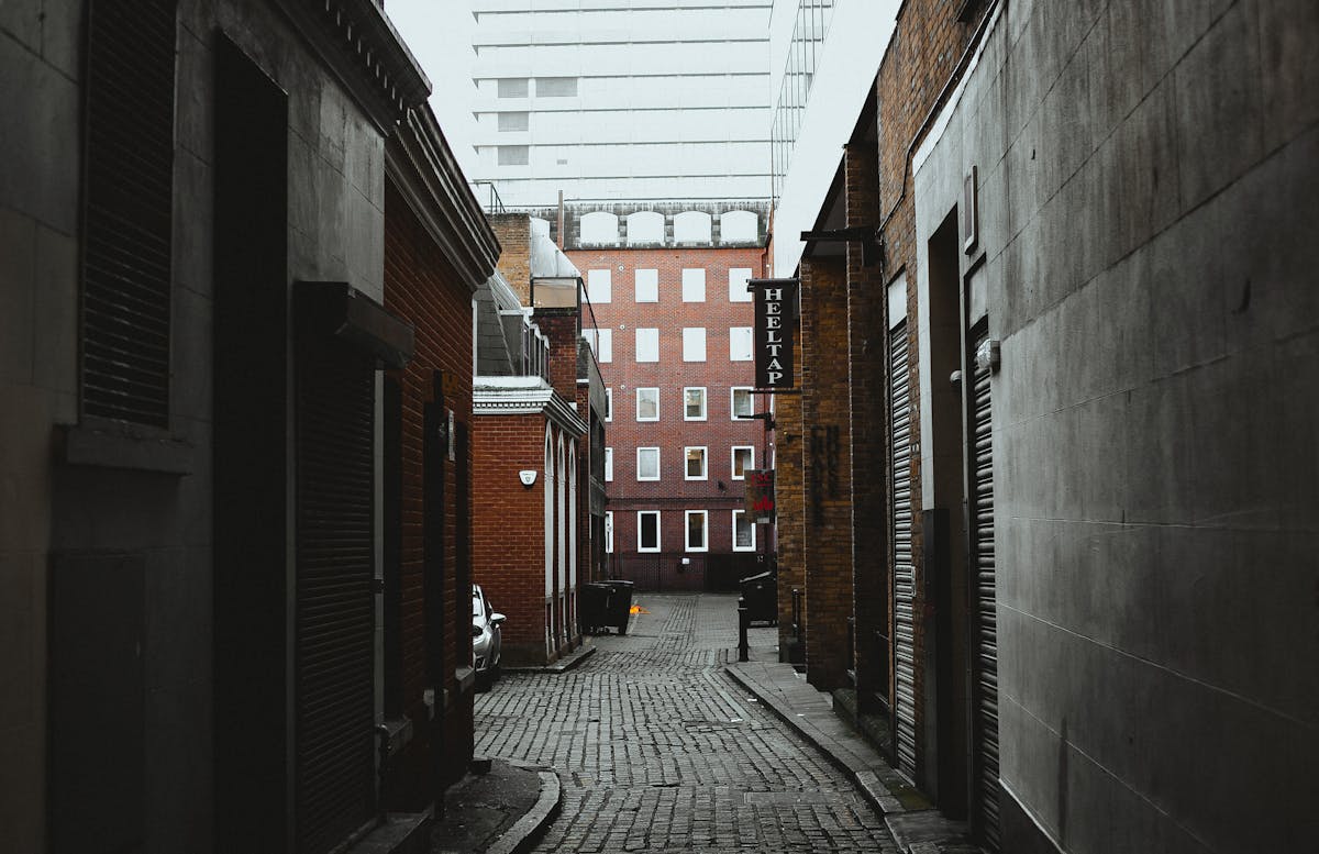 Empty narrow alleyway between historic brick buildings in London
