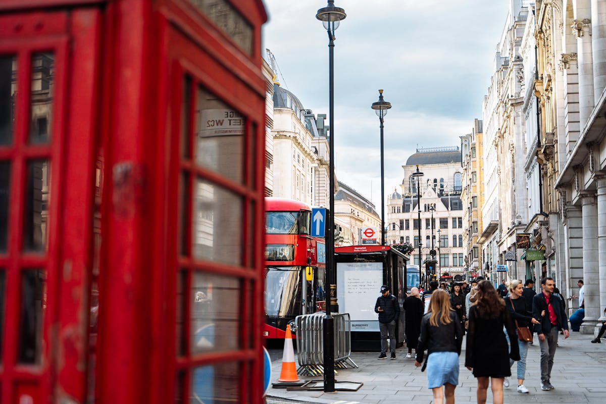 Classic red phone booth on a London street with historic buildings