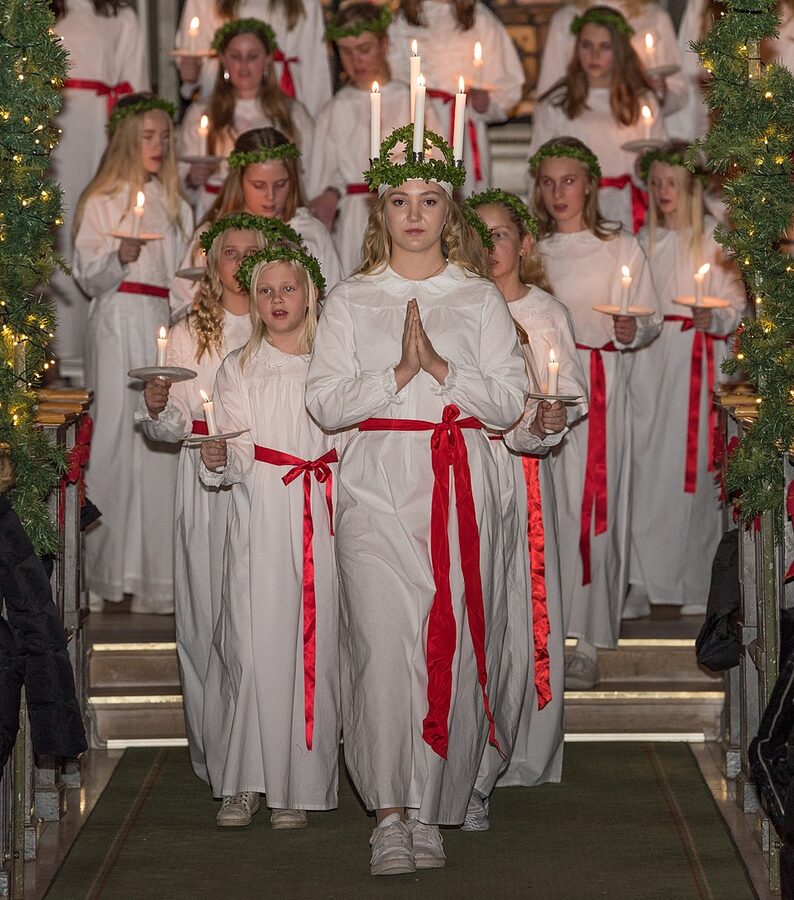 Swedish Lucia procession with candles in white robes