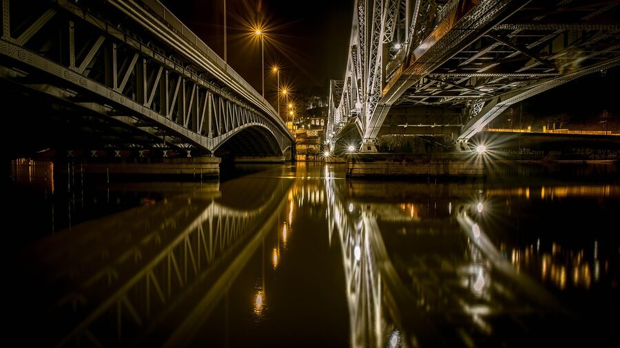 Bridge over the Saone river at night in Lyon with city lights reflecting on water
