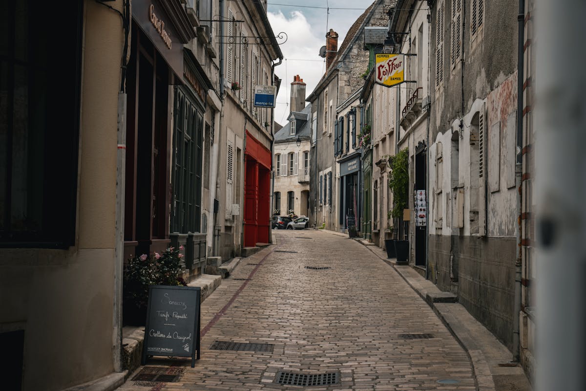 Cobblestone street in historic French town with cafe