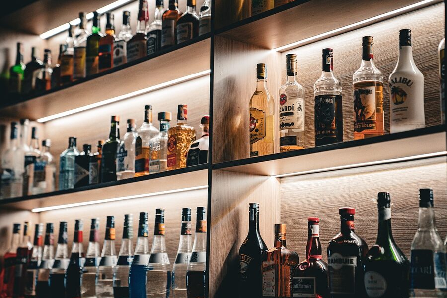 Warm-toned bar interior with wine bottles lining the shelves