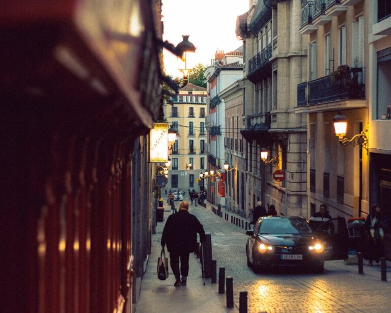 A man walking through Madrid cobblestone streets at twilight