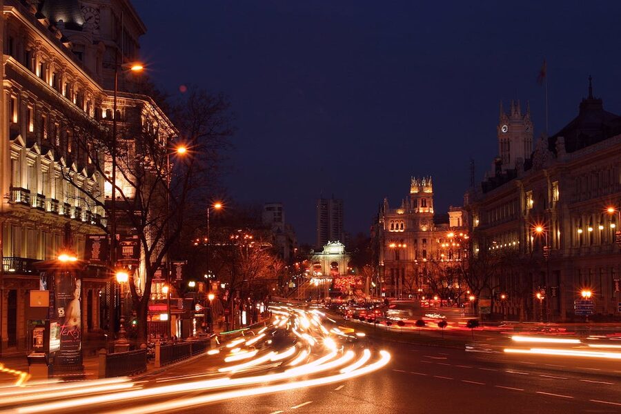Madrid downtown at night with blurred car light trails and architecture