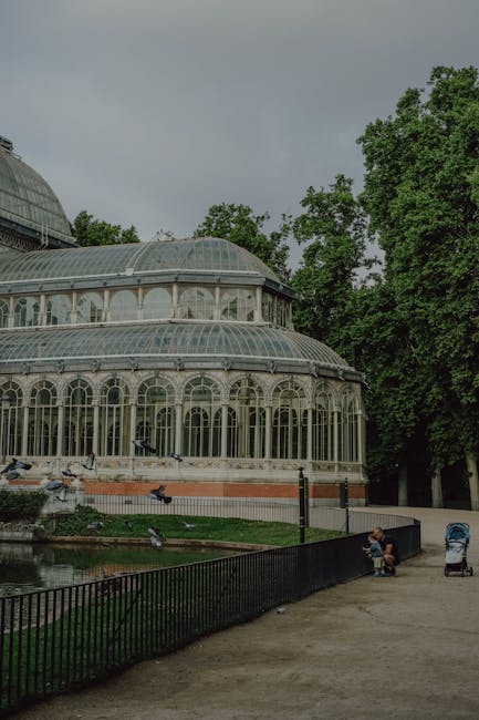 The Crystal Palace in Retiro Park Madrid surrounded by green trees