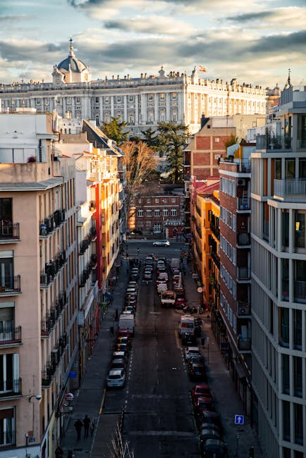 A colorful Madrid street with historic buildings leading toward the Royal Palace in the background