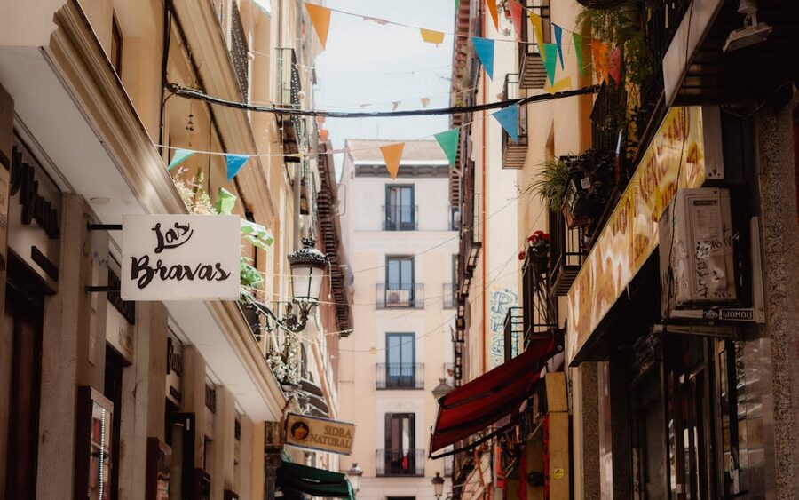 A Madrid street decorated with flags and traditional shop fronts
