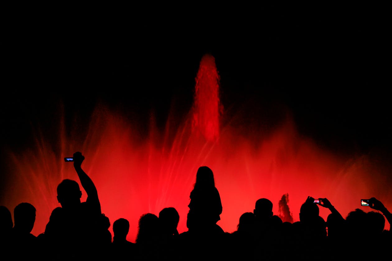 Silhouetted crowd watching the Magic Fountain light show at night in Barcelona