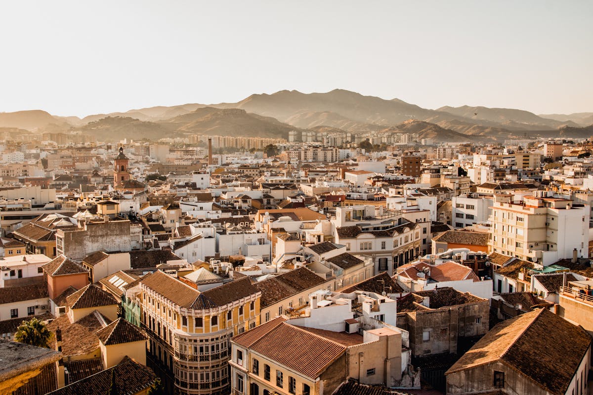 Aerial view of Malaga cityscape with mountains in the background during golden hour