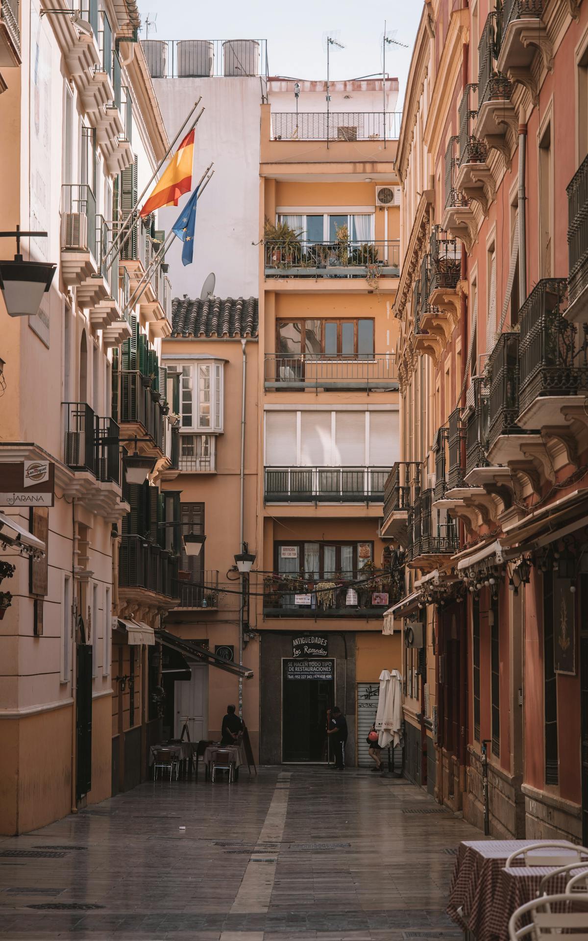 Charming narrow street in Malaga Spain decorated with balconies and Spanish flags
