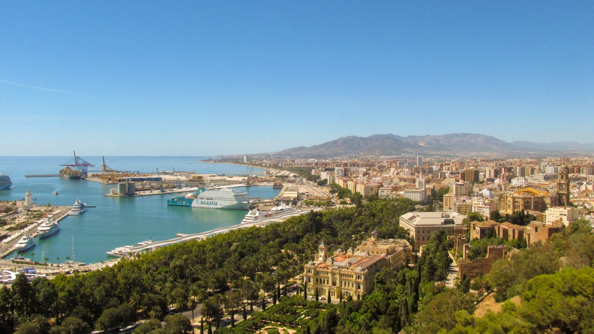 Aerial view of Malaga city with port and coastal line under clear sky