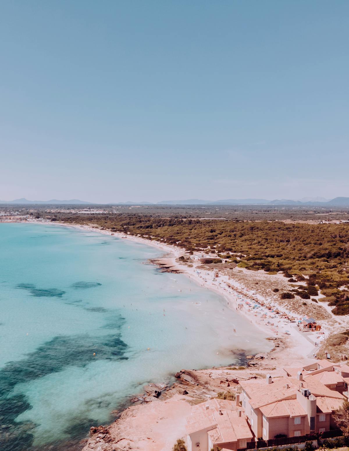 Stunning drone shot of Mallorca coastline with turquoise waters and sandy beach surrounded by cliffs