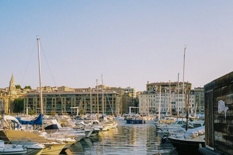 Boats moored at Marseille Vieux-Port with historic buildings in warm morning light