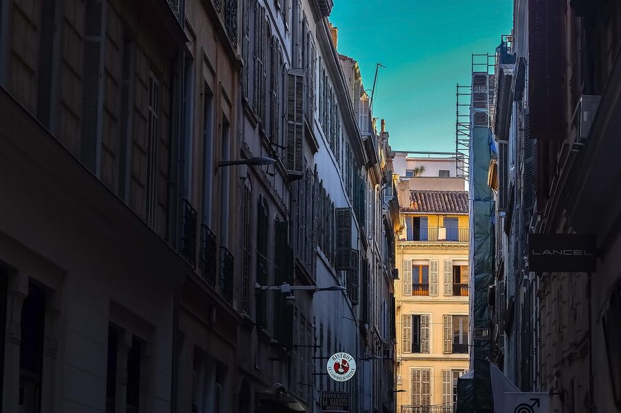 Narrow stone-walled alley in the old quarter of Marseille with colorful facades