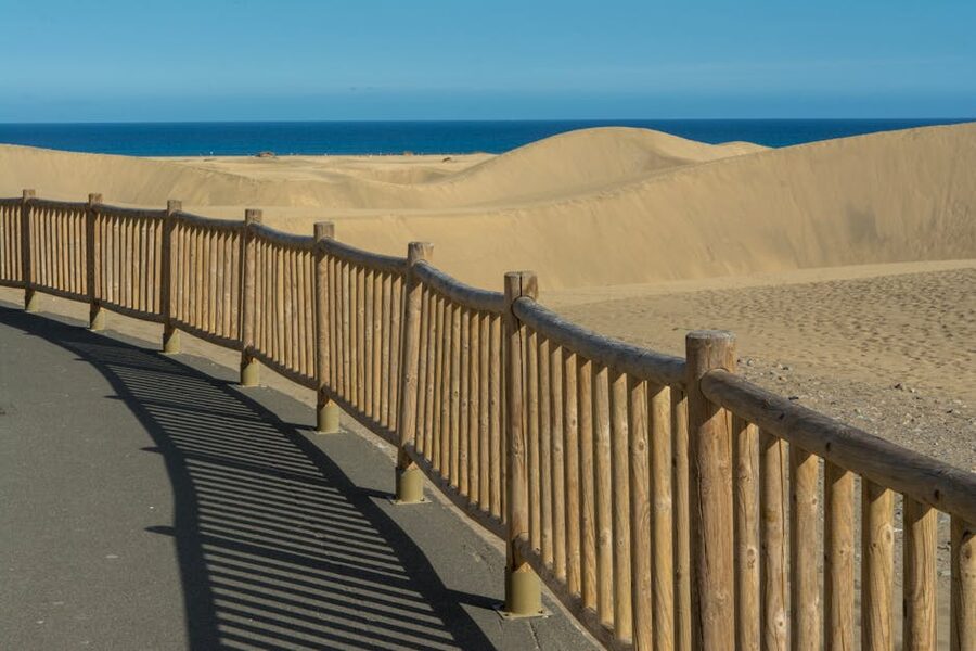 Wooden walkway leading through dunes to the ocean at Maspalomas Gran Canaria
