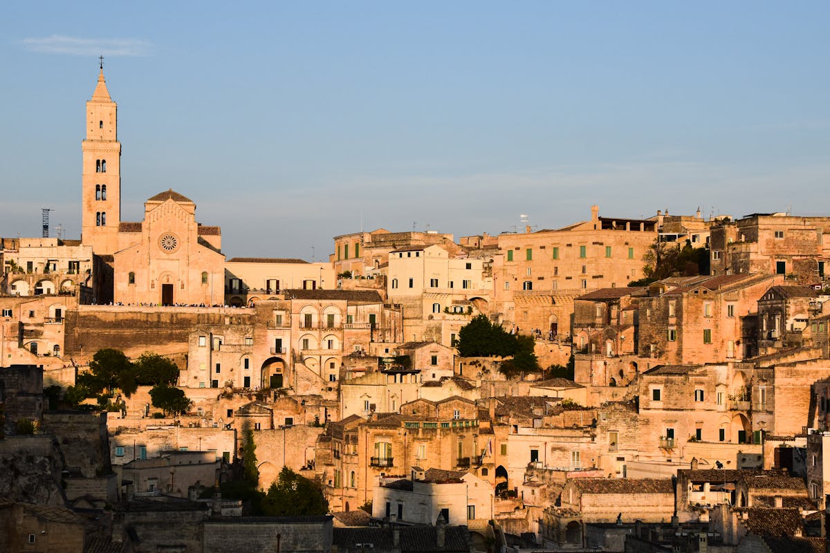 Matera old town glowing at golden hour seen from a viewpoint across the ravine