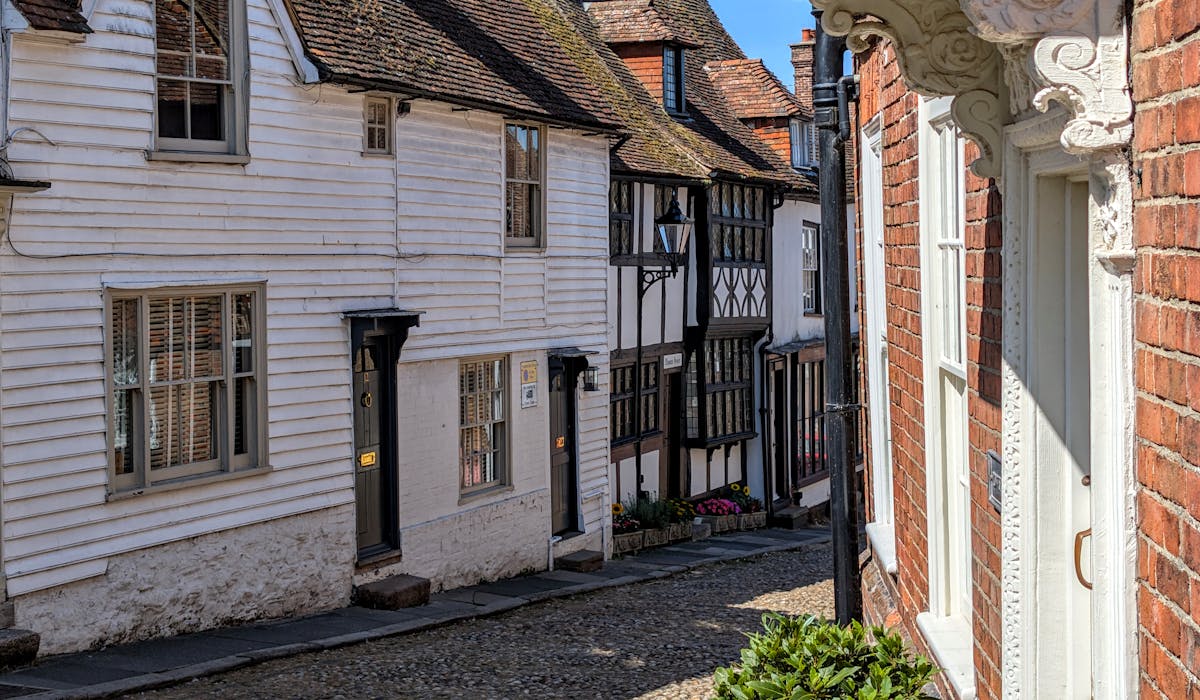Narrow cobbled street lined with medieval timber-framed buildings in an English town