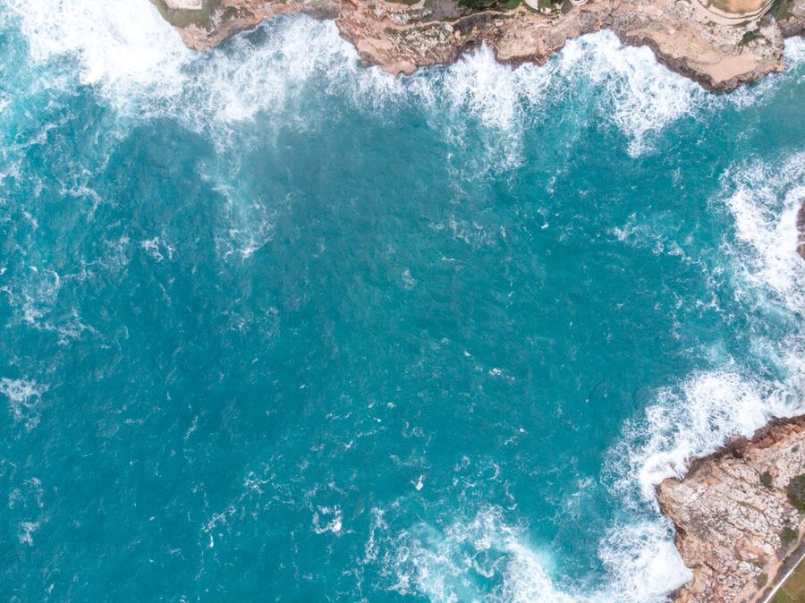 Aerial drone view of the rocky coastline and blue waters of Menorca