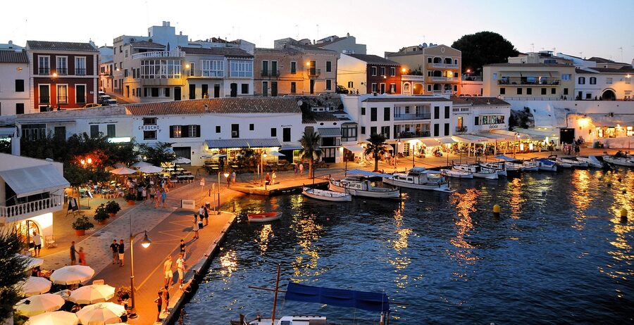 Es Castell harbour with boats and waterfront buildings in Menorca