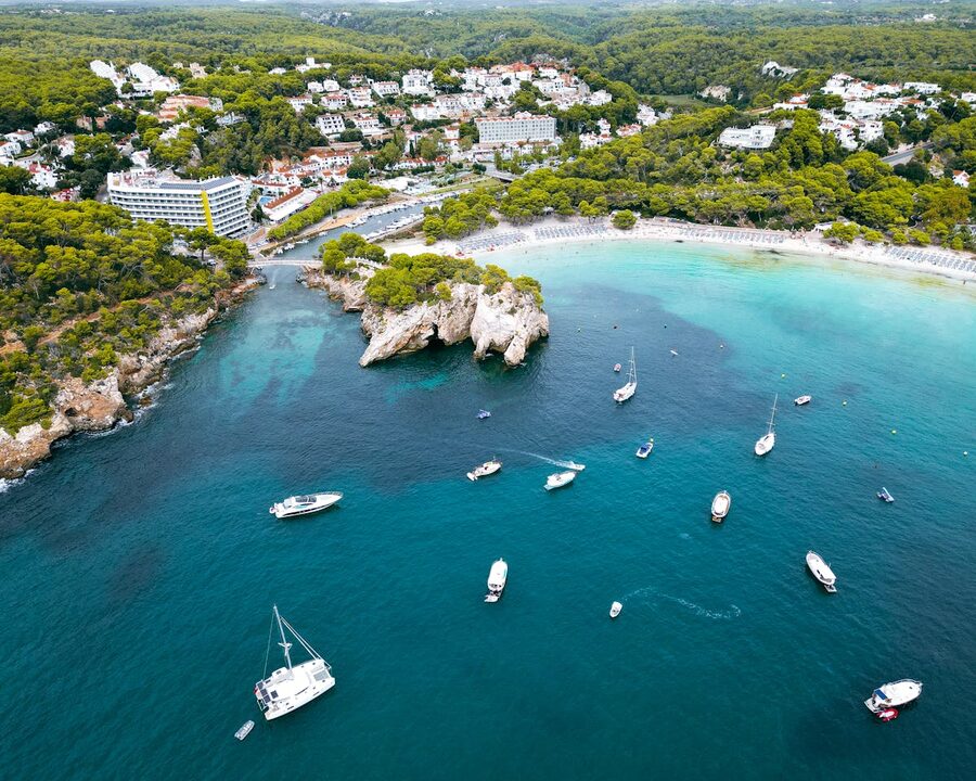 Sailboats anchored in the clear blue waters of Cala Galdana Menorca