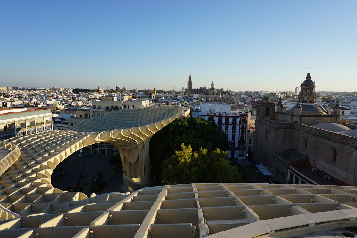 Panoramic view of Metropol Parasol and Seville skyline at sunset with historical buildings
