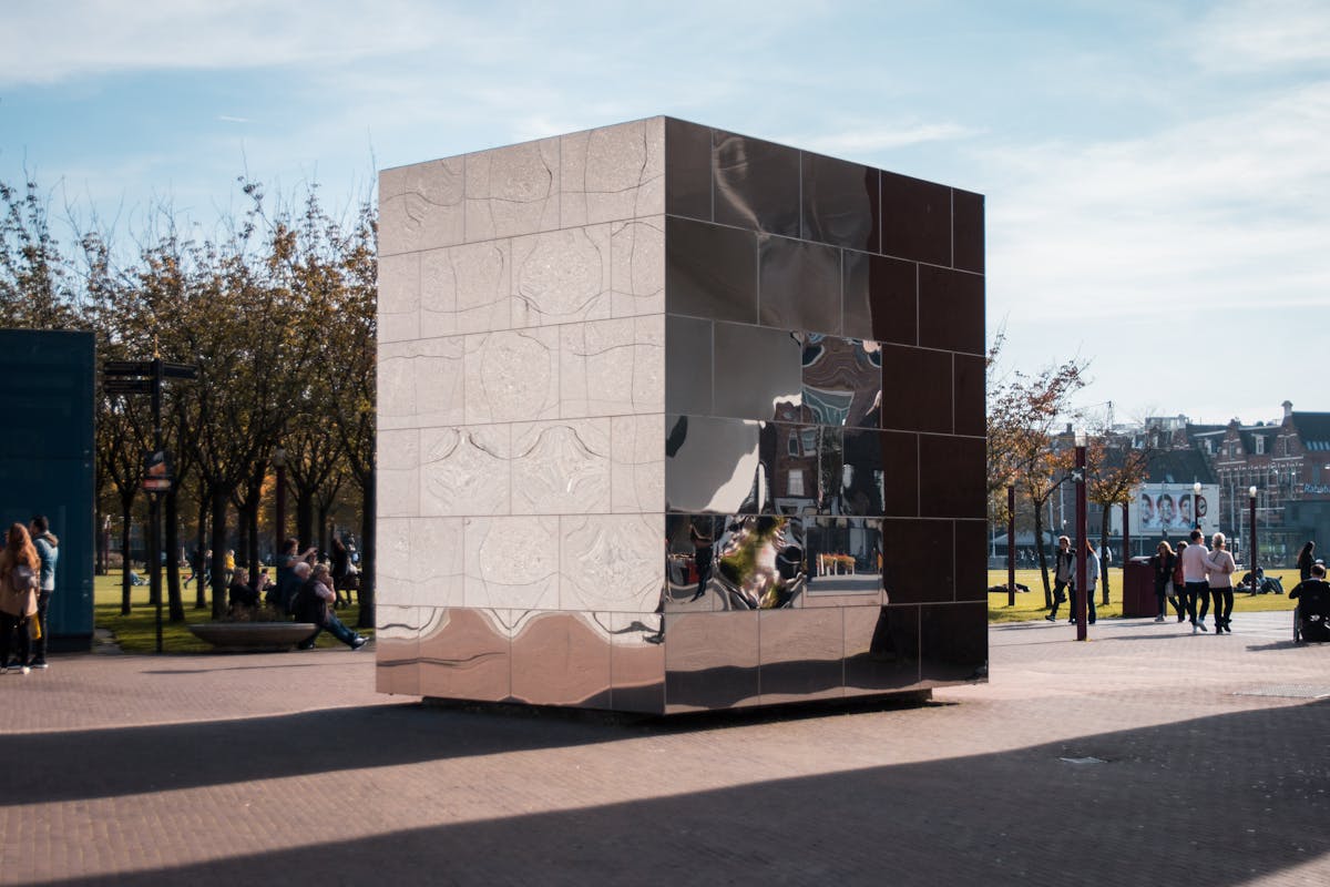 Modern reflective cube art installation in an outdoor Amsterdam setting