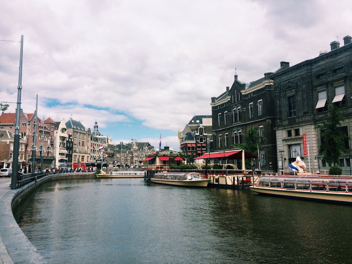 Amsterdam canal with tour boats and historic architecture