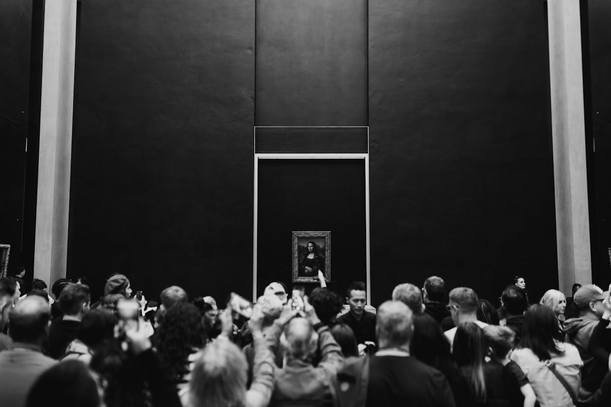 A large crowd of visitors gathered around the Mona Lisa painting at the Louvre