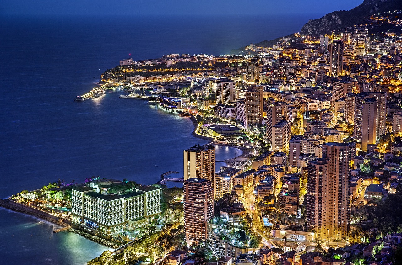 Monaco cityscape at blue hour with illuminated buildings along the coast