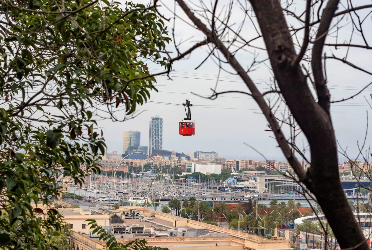 Cable car suspended over Barcelona with the city skyline and harbour in the background