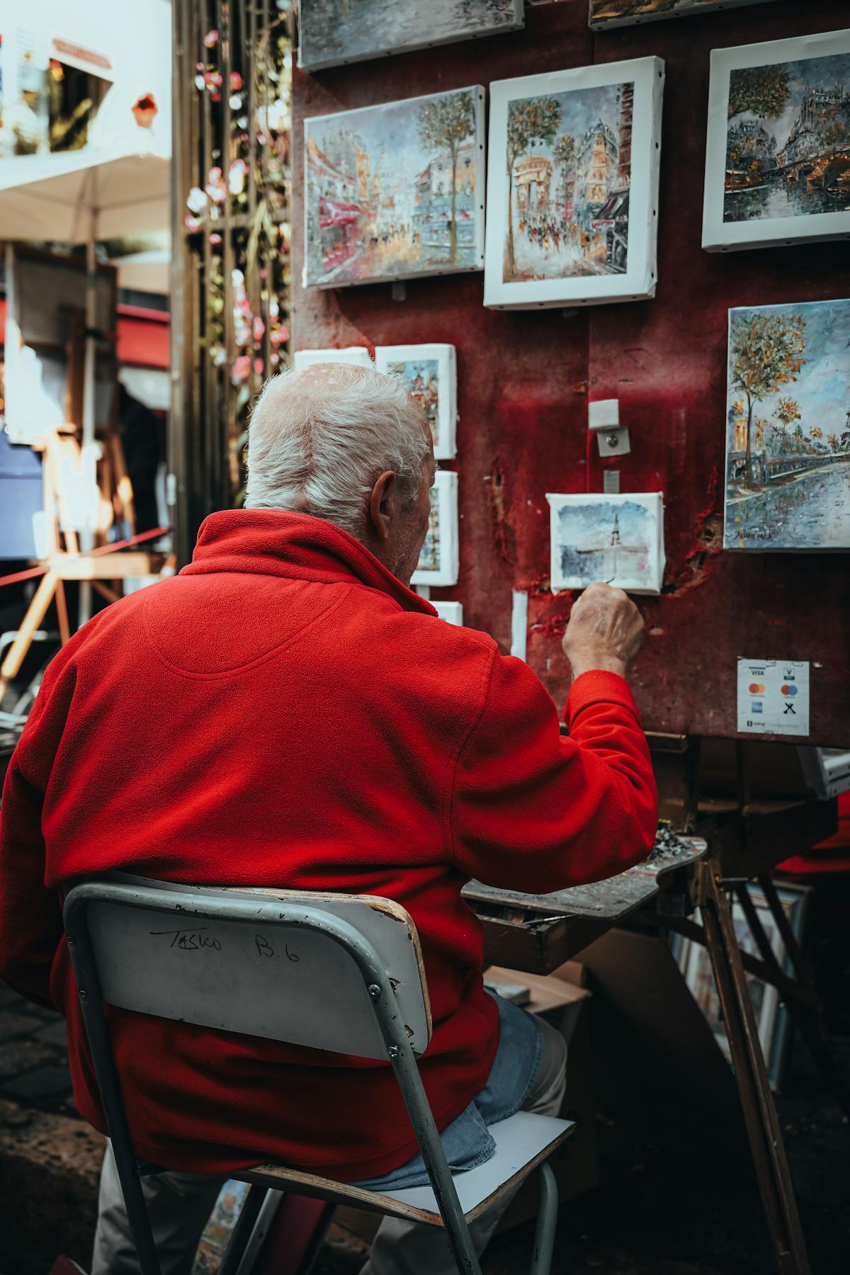 An artist painting a Montmartre street scene on a sunny day