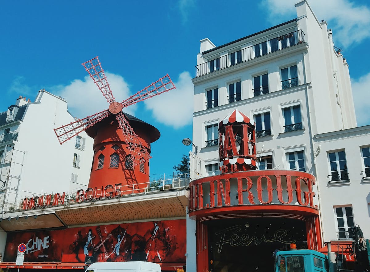 The Moulin Rouge red windmill seen during the day against a clear blue Paris sky
