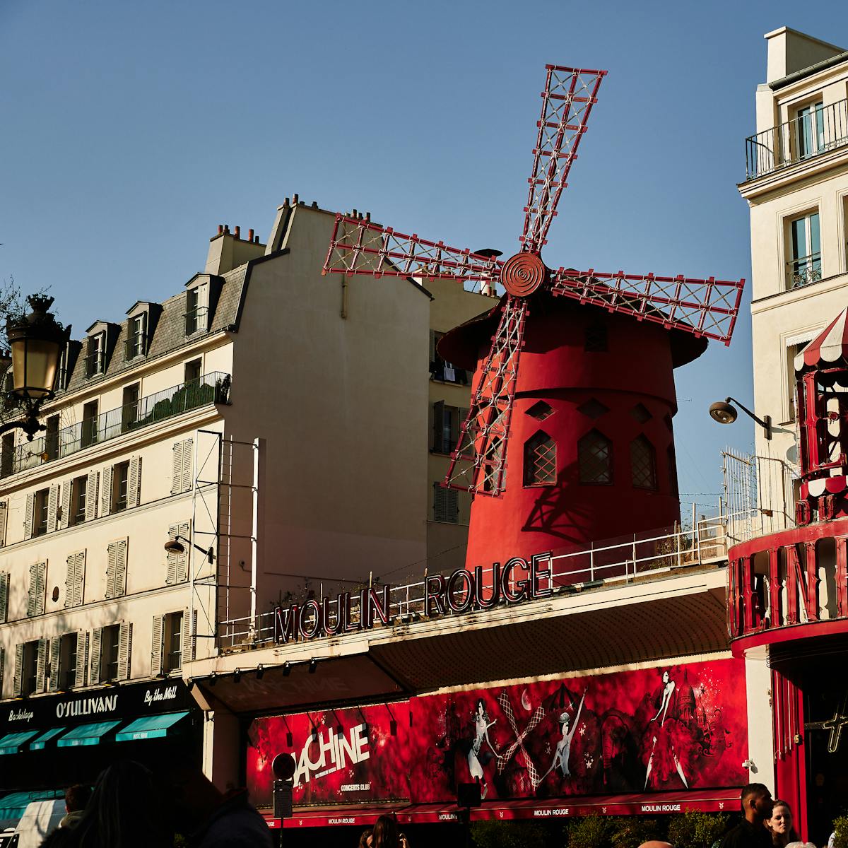 The full facade of the Moulin Rouge cabaret showing its red exterior and marquee