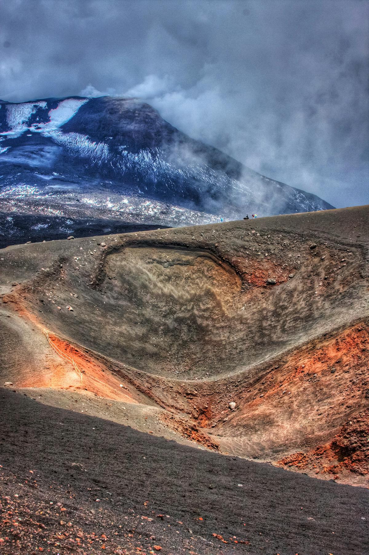 Mount Etna dramatic crater surrounded by swirling clouds