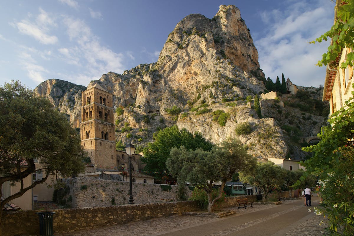 Moustiers-Sainte-Marie village with historic buildings and majestic cliffs at golden hour in Provence France
