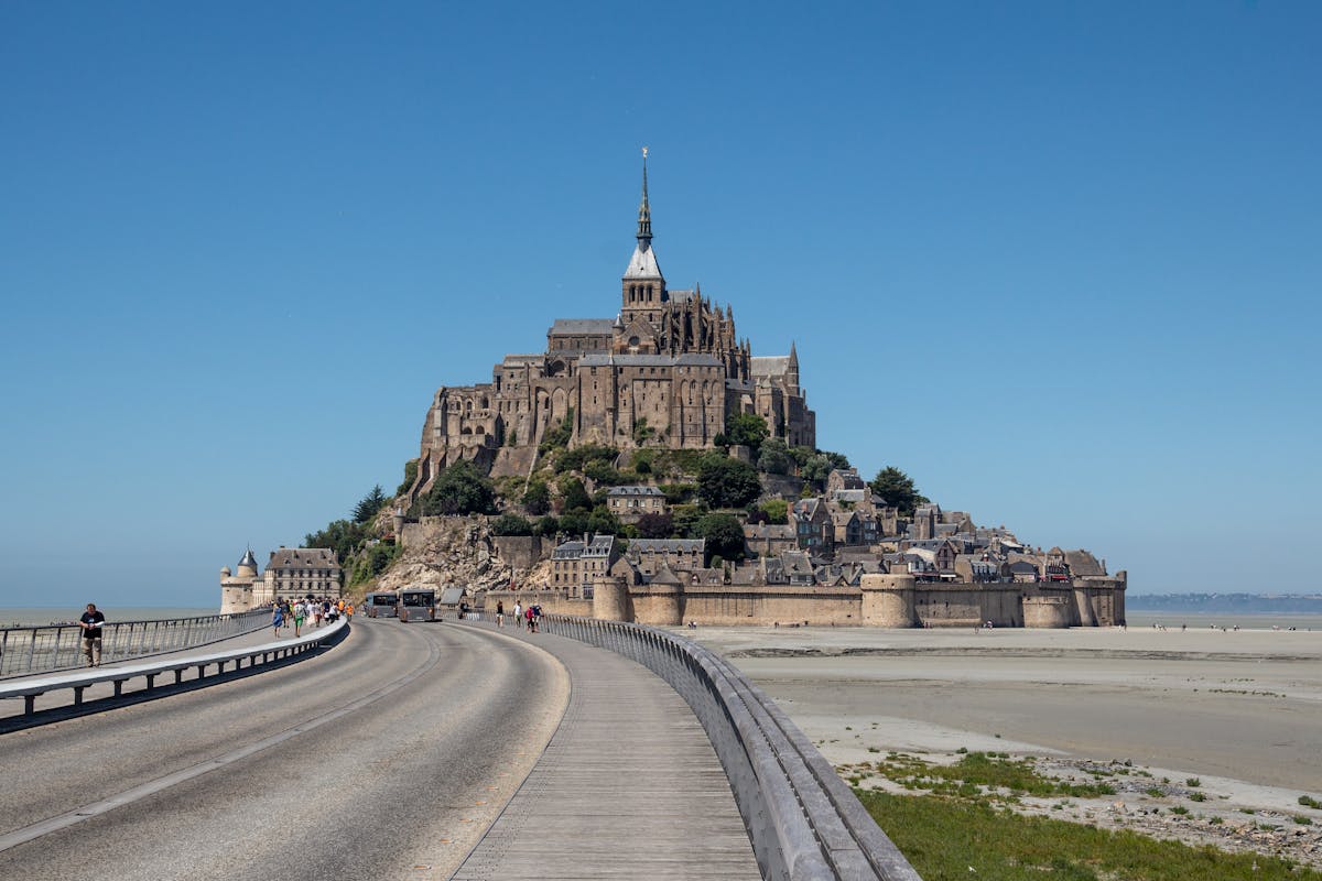 Mont Saint-Michel standing tall beneath a blue sky on a clear afternoon
