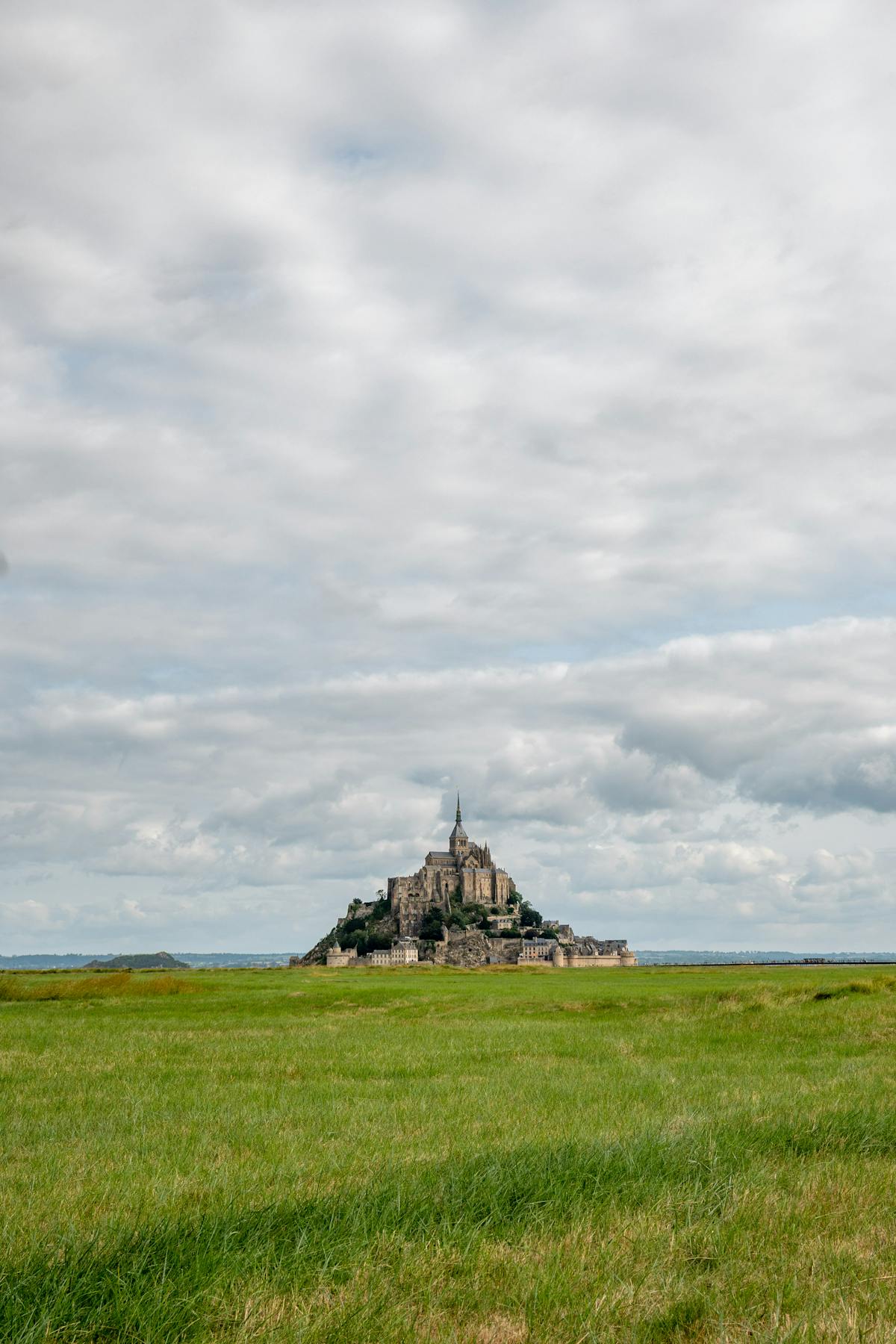 Mont Saint-Michel visible across green fields in the Normandy countryside