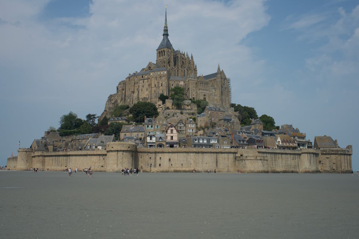 Mont Saint-Michel on a clear day with the bay stretching behind it