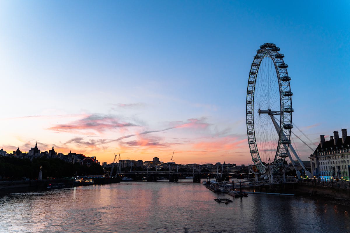 London Eye silhouetted against sunset sky over the Thames