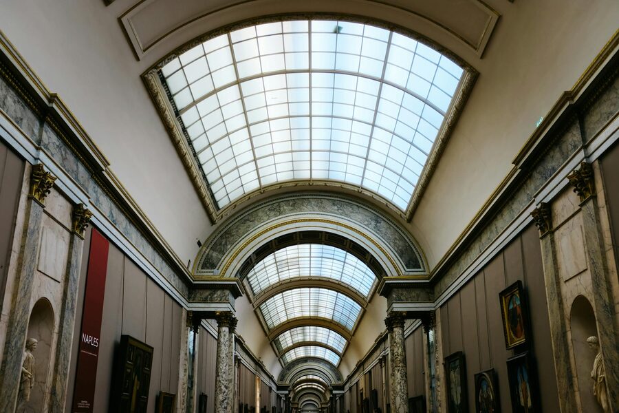 Interior view of a grand museum hallway with elegant glass ceiling