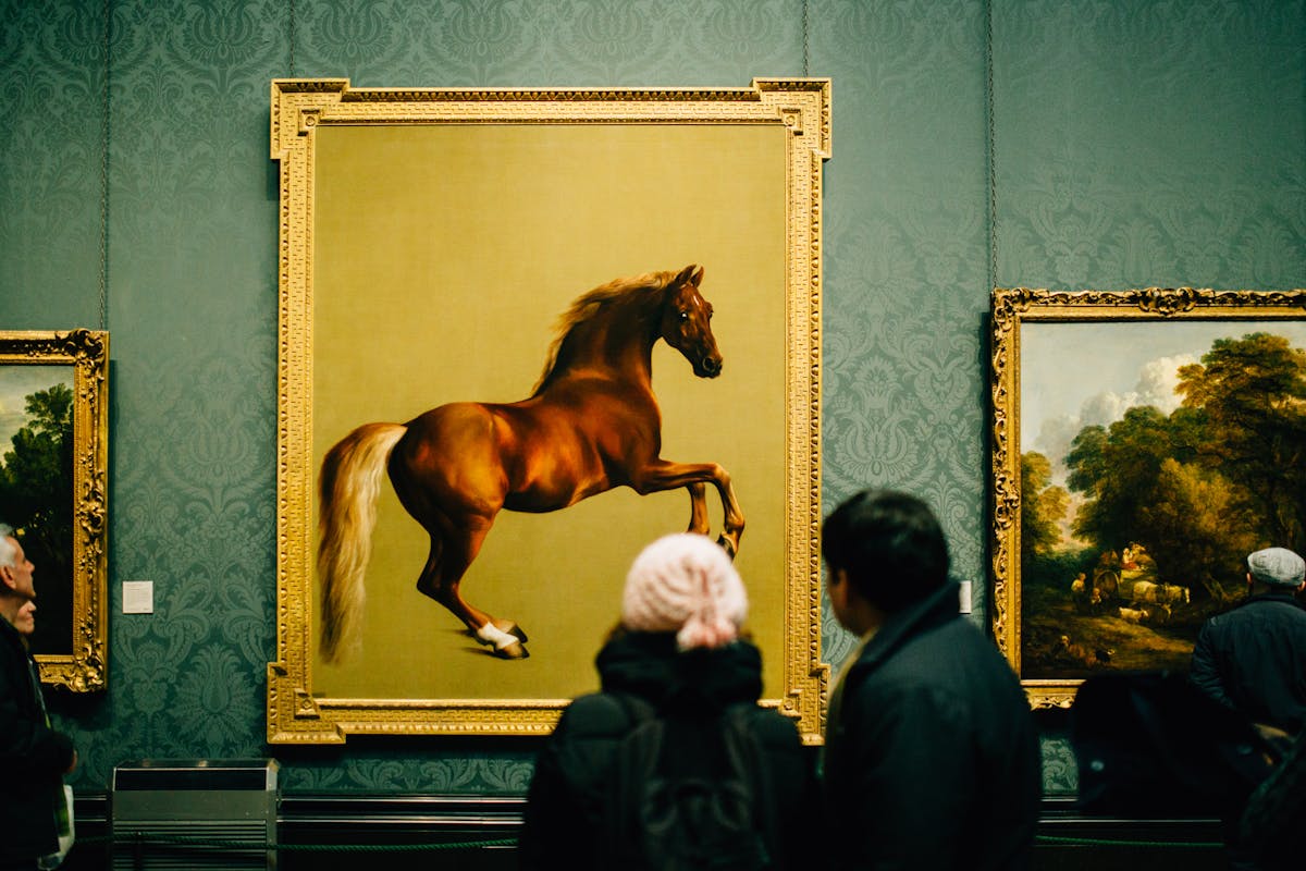 Visitors admiring a large painting of a horse in a museum gallery
