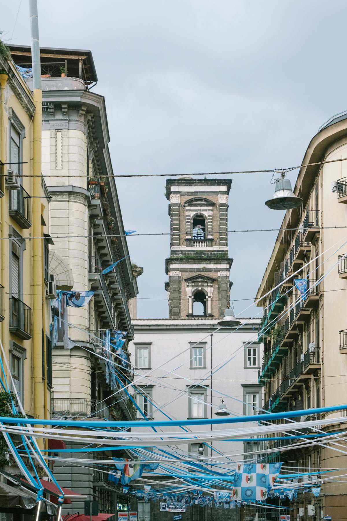 Bell tower in Naples surrounded by decorated city streets